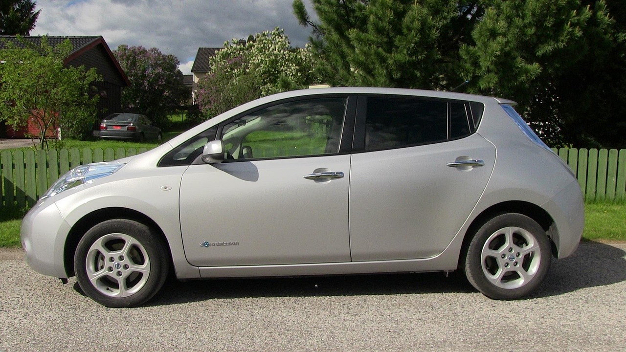A silver car parked in front of a New Zealand home and front lawn.