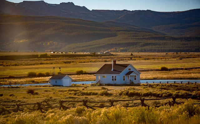 A New Zealand rural home with a large shed and fencing in the background, illustrating FMG Insurance's home policy that covers additional structures including garages, sheds, gates, and fences for Kiwi homeowners in 2026.