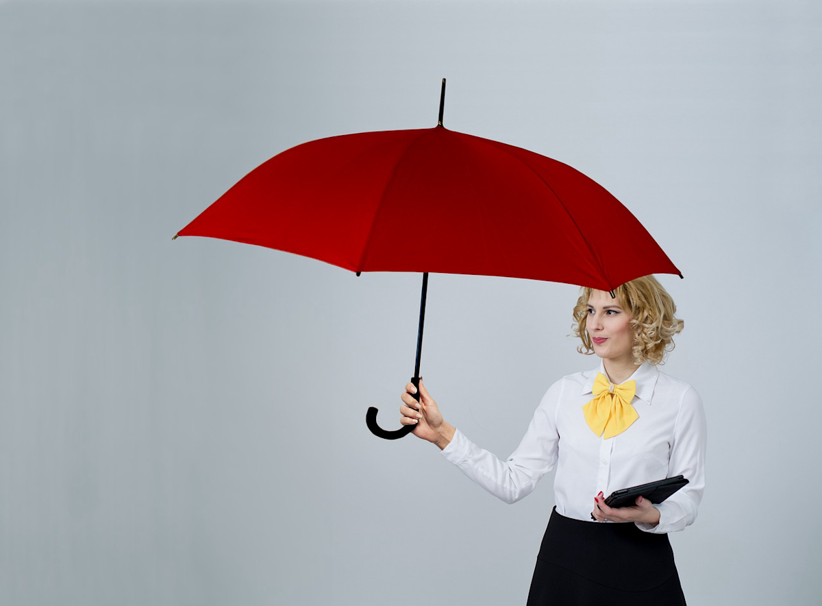 A woman holding a red umbrella and a tablet.