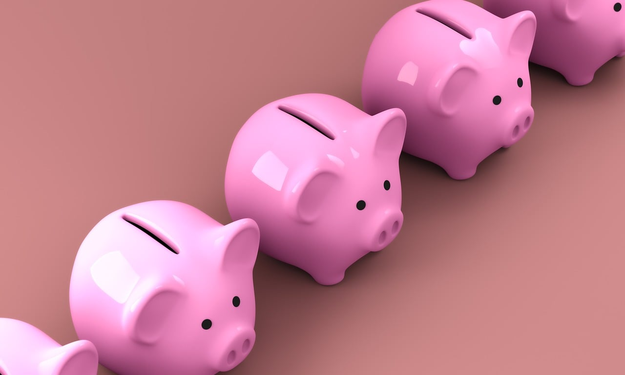 A diagonal row of pink ceramic piggy banks, representing insurance costs and savings for New Zealanders using the Quashed Market Scan in 2026.