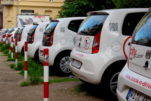 A line of white rental cars in a parking area, relevant to understanding rental excess and travel insurance in 2026 with Quashed.
