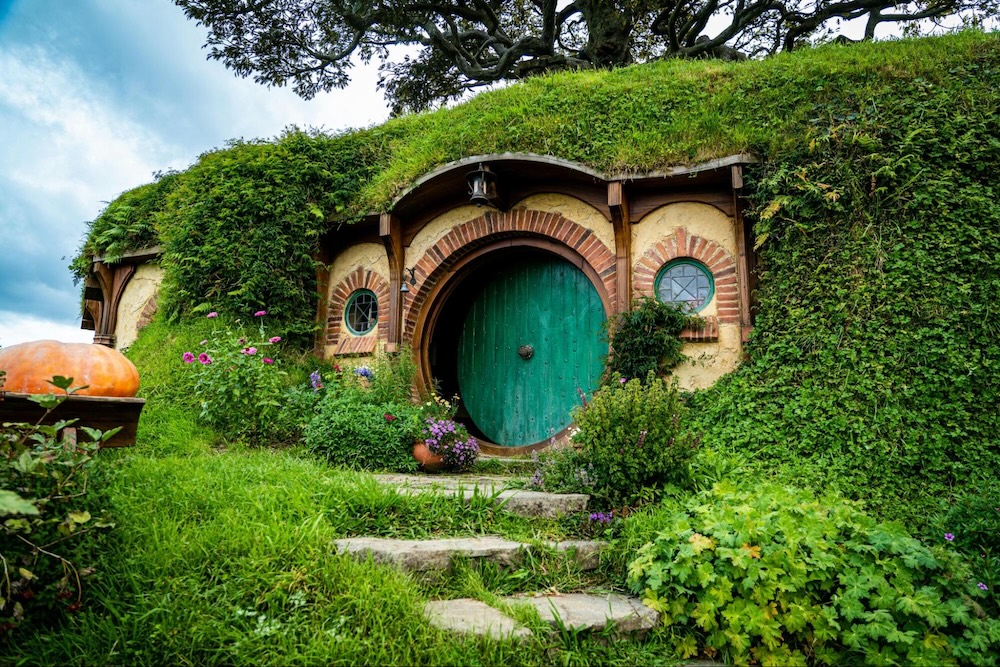 A lush green Hobbit-style house in New Zealand, used to illustrate NZ properties in the Quashed 2026 Find Cheaper House Insurance Guide