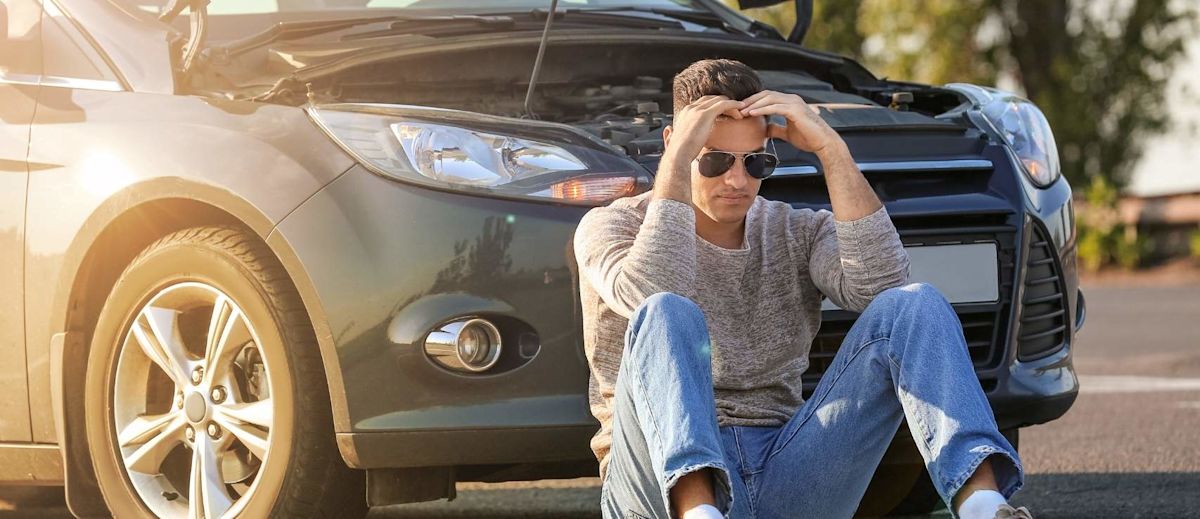 A driver sitting outside their vehicle.