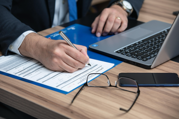 A car insurance claim form on a desk next to car keys, representing how New Zealand insurers calculate total loss payouts and why Quashed recommends comparing agreed value policies in 2026.