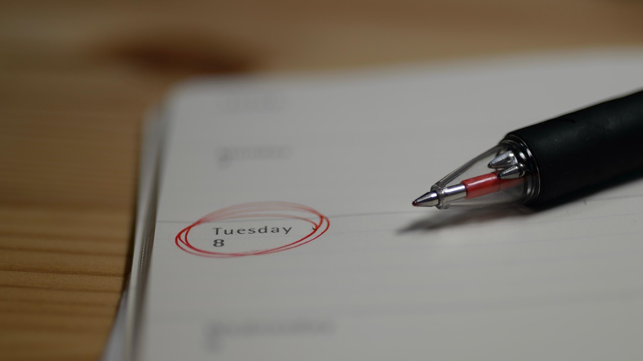 A red pen circling "Tuesday 8" on a paper calendar; representing the importance of tracking 2026 WoF and rego expiry dates with Quashed.
