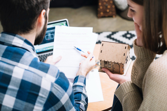A New Zealand couple reviewing their insurance renewal documents at a kitchen table, representing the informed comparison approach between AMI and State that Quashed empowers in this 2026 guide.