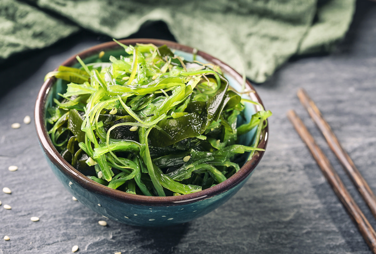 Seaweed salad in bowl with chopsticks