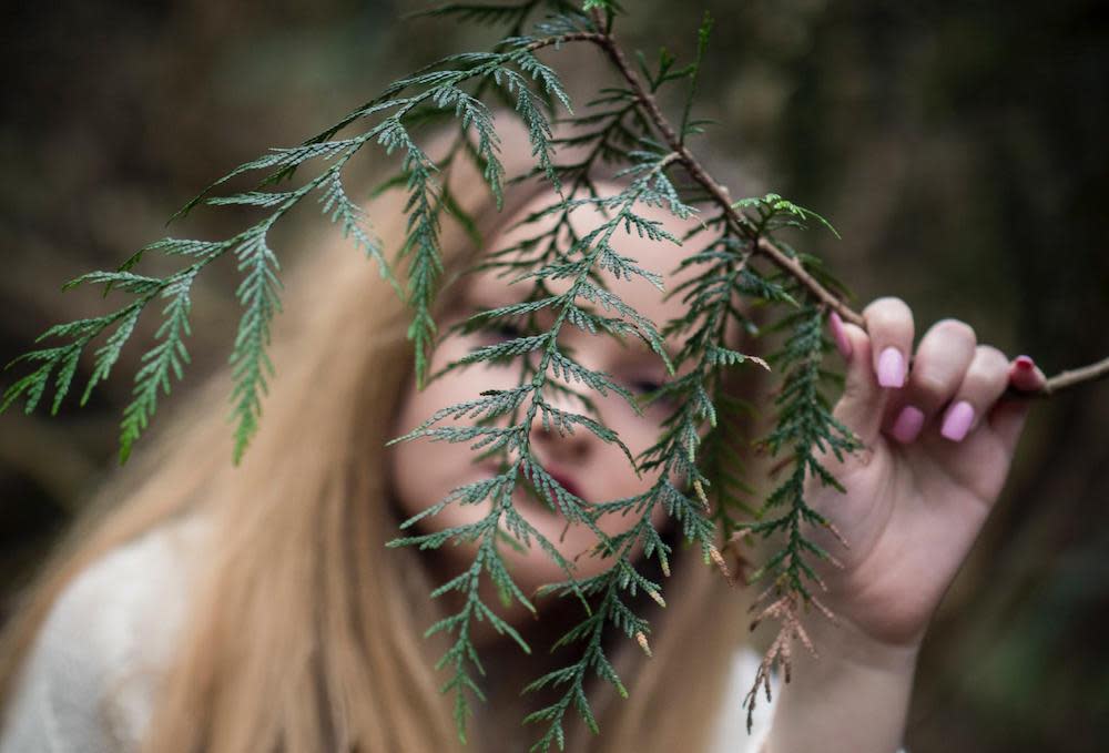 A woman behind branch of tree