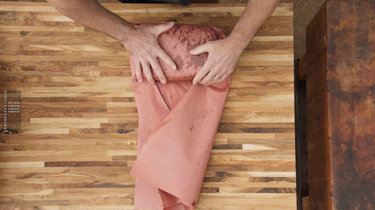 Aaron Franklin wrapping meat in red paper step 4