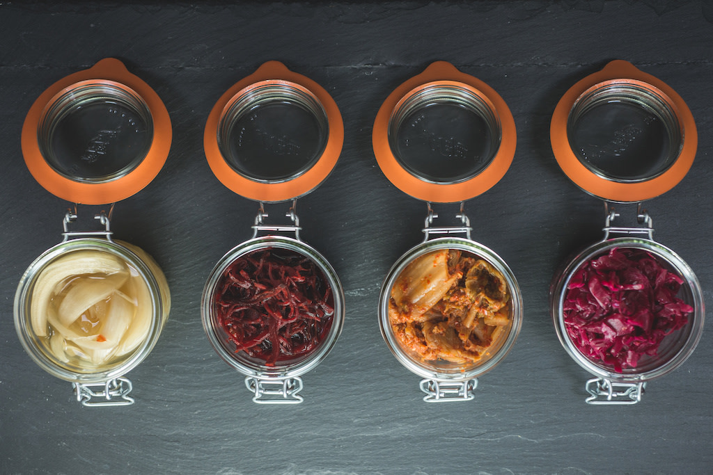 Different types of kimchi in glass jars