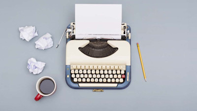 Vintage typewriter with coffee and crumpled pieces of paper