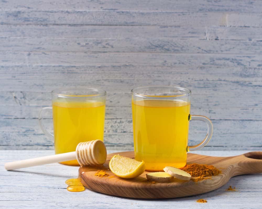 Turmeric tonic in glass mug with honey and lemon