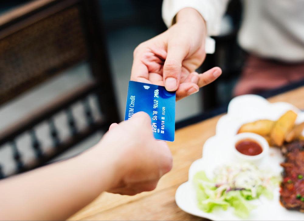 A person exchanging a credit card to illustrate compounding interest