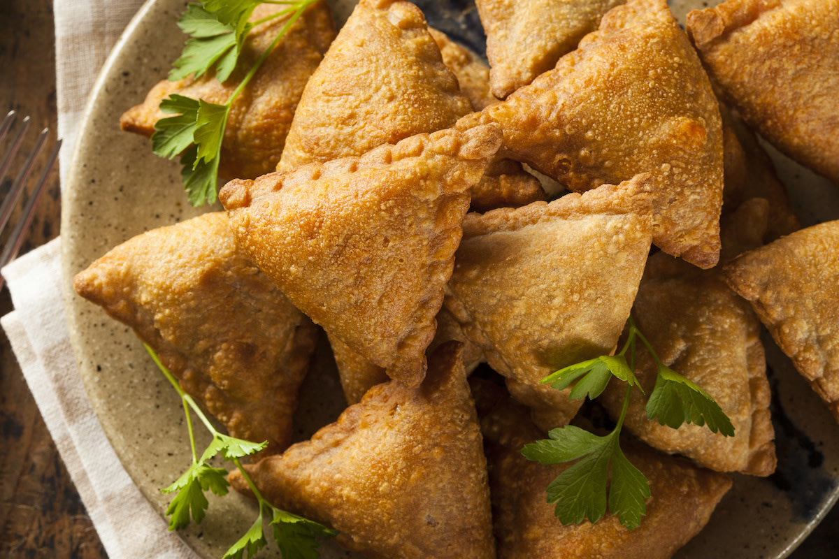 Samosas on plate with parsley up-close