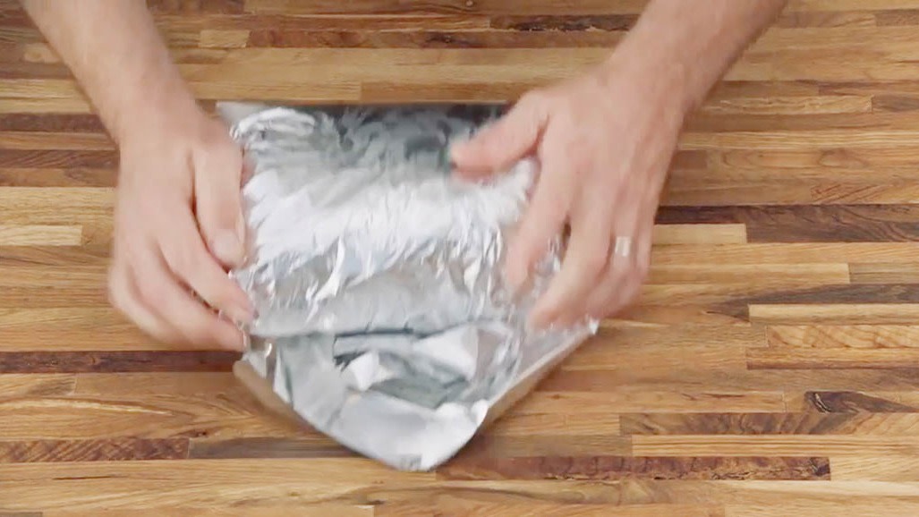 Aaron Franklin wrapping meat in tinfoil with both hands