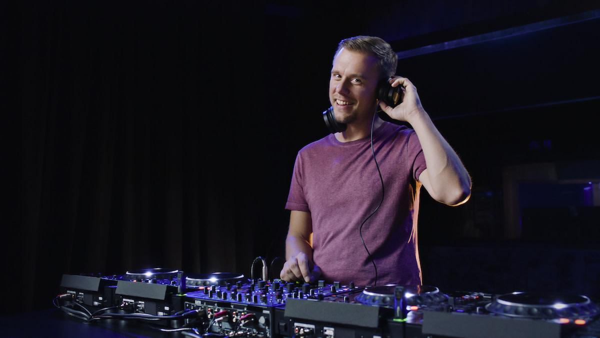 Armin van Buuren in front of mix table with headphones