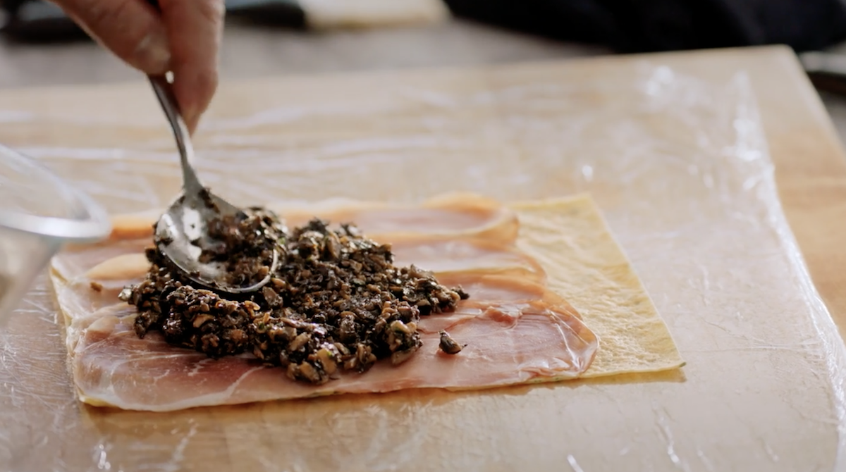 Gordon Ramsay spreading mushrooms on prosciutto 