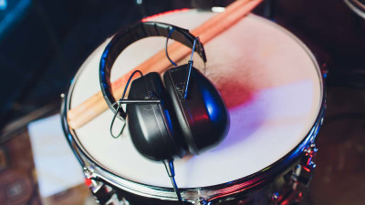 Headphones on drum with drum sticks