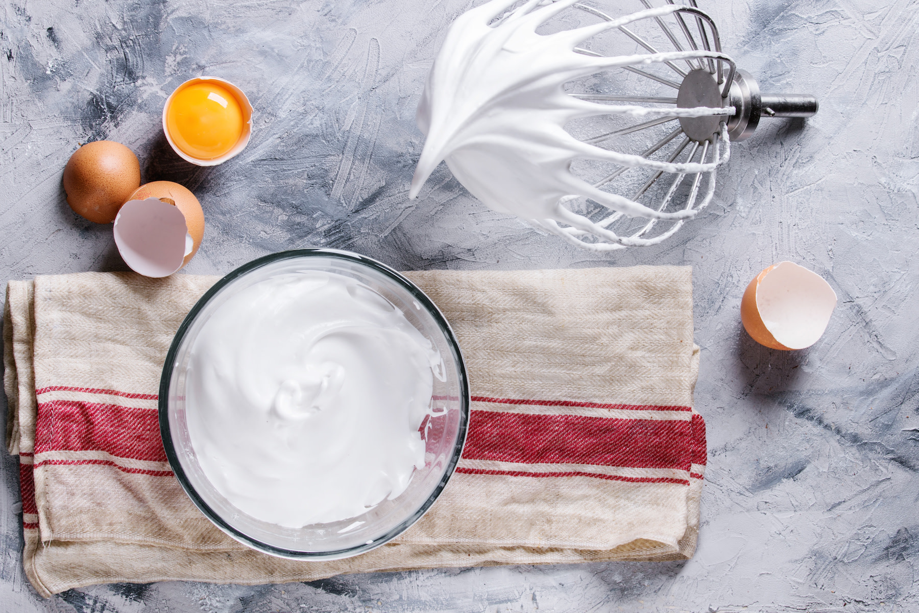 Meringue on whisk with ingredients on cloth