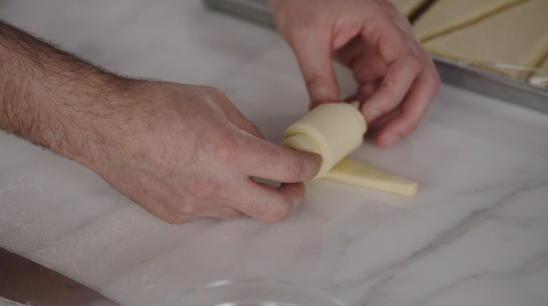 Dominique Ansel rolling dough into croissant