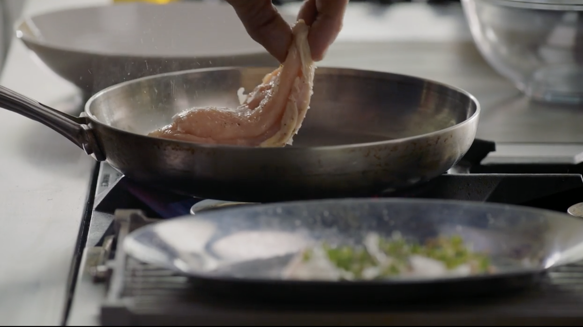 Gordon Ramsay putting raw chicken into pan