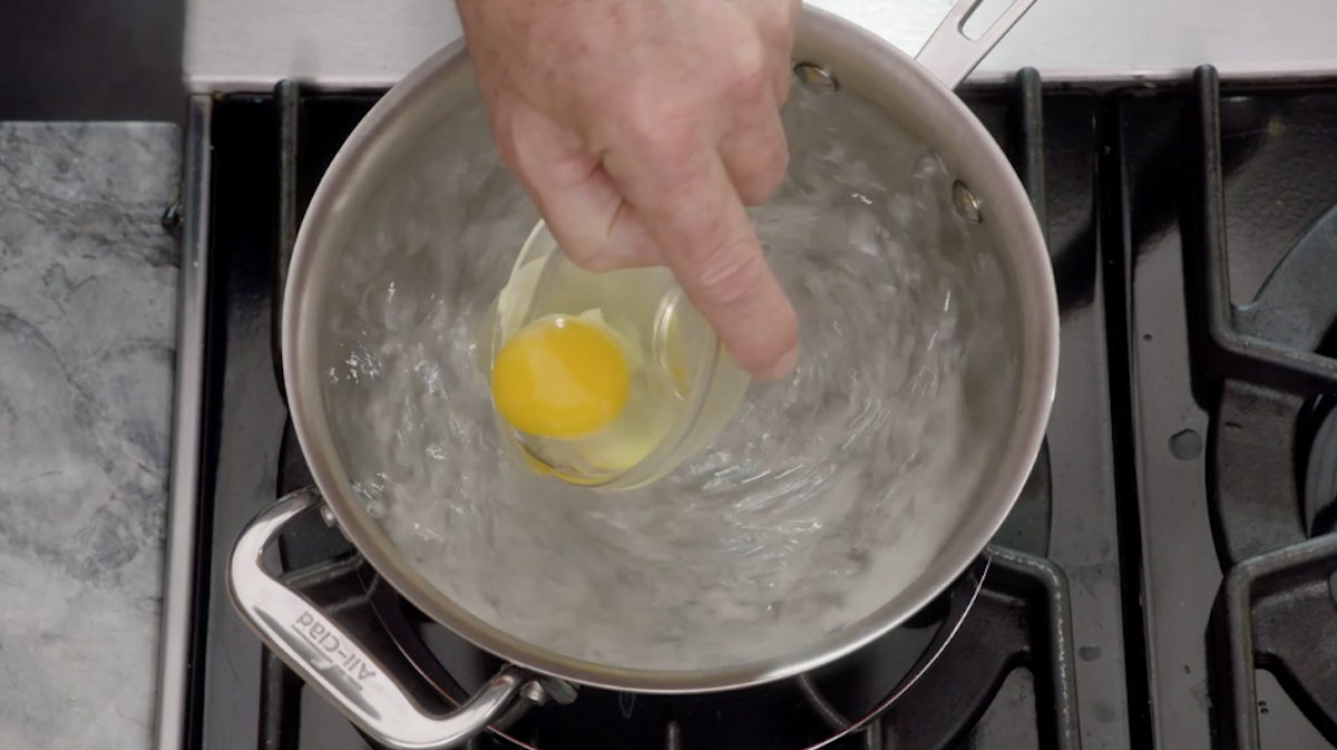 Chef Thomas Keller putting raw egg into boiling water