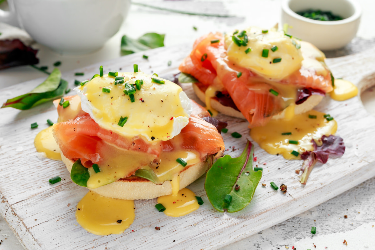 Salmon eggs Benedict on white wood