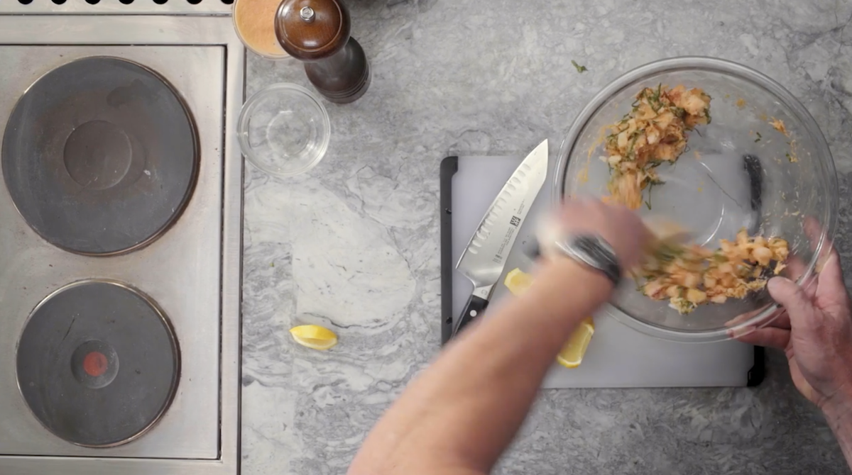 Gordon Ramsay mixing salmon stuffing in glass bowl