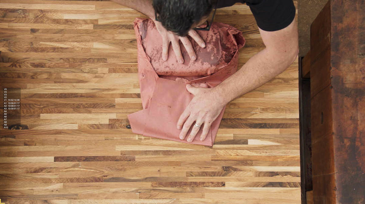 Aaron Franklin wrapping brisket in red paper step 5