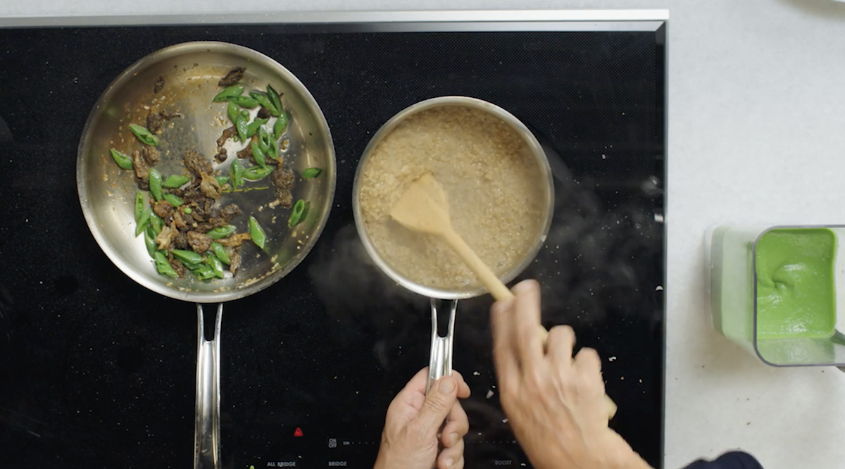 Wolfgang Puck stirring oats on stove with vegetables