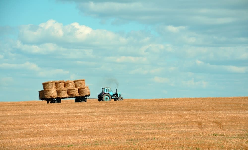 a tractor on a farm which is part of the larger economy