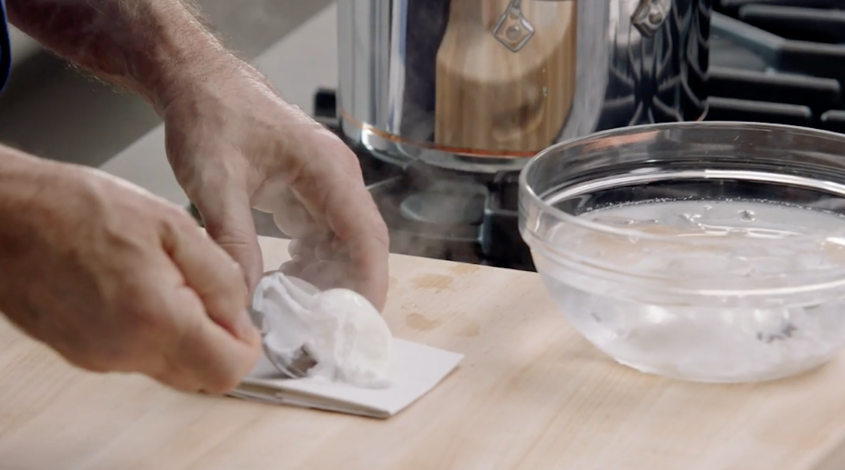 Chef Thomas Keller placing poached egg on paper towel