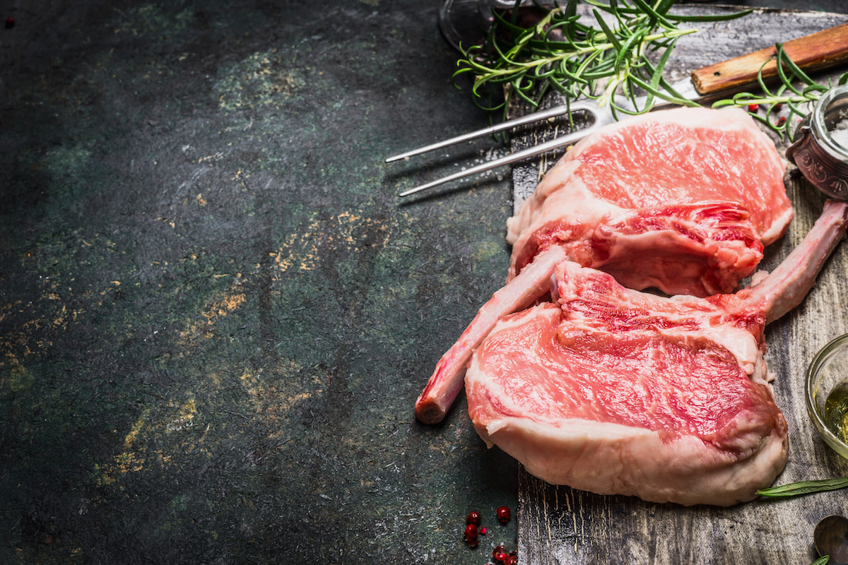 Raw pork chops on cutting board