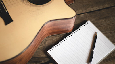 a guitar with a pad of paper