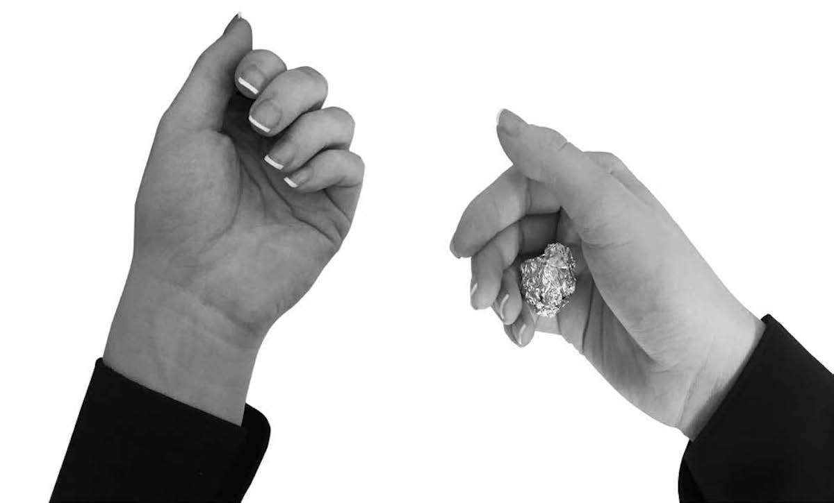 Woman's hands curled with tinfoil ball