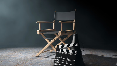Director chair and movie clapperboard on black background