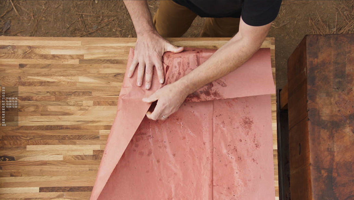 Aaron Franklin wrapping meat in red paper step 2