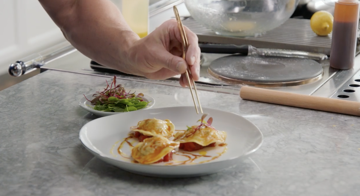 Gordon Ramsay placing microgreens onto raviolis