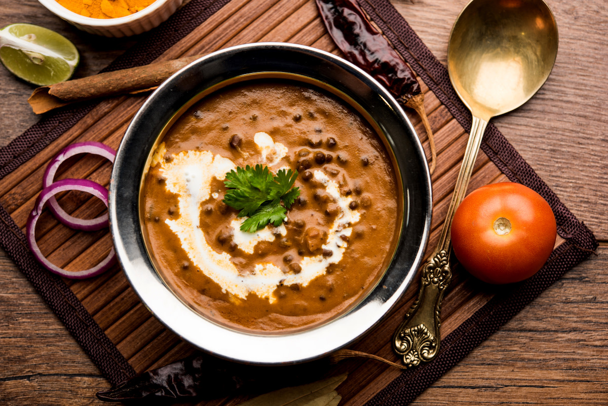 Dal makkhani in bowl with spoon and ingredients