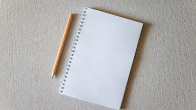Notepad and pencil on white background