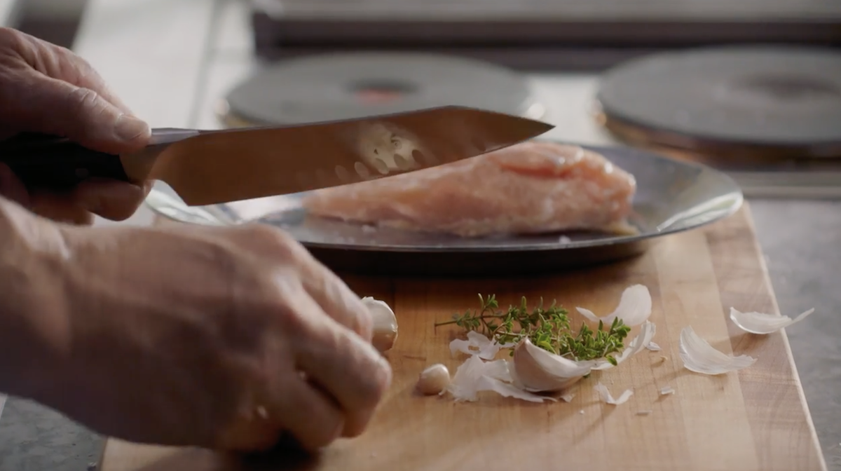 Gordon Ramsay chopping garlic on cutting board