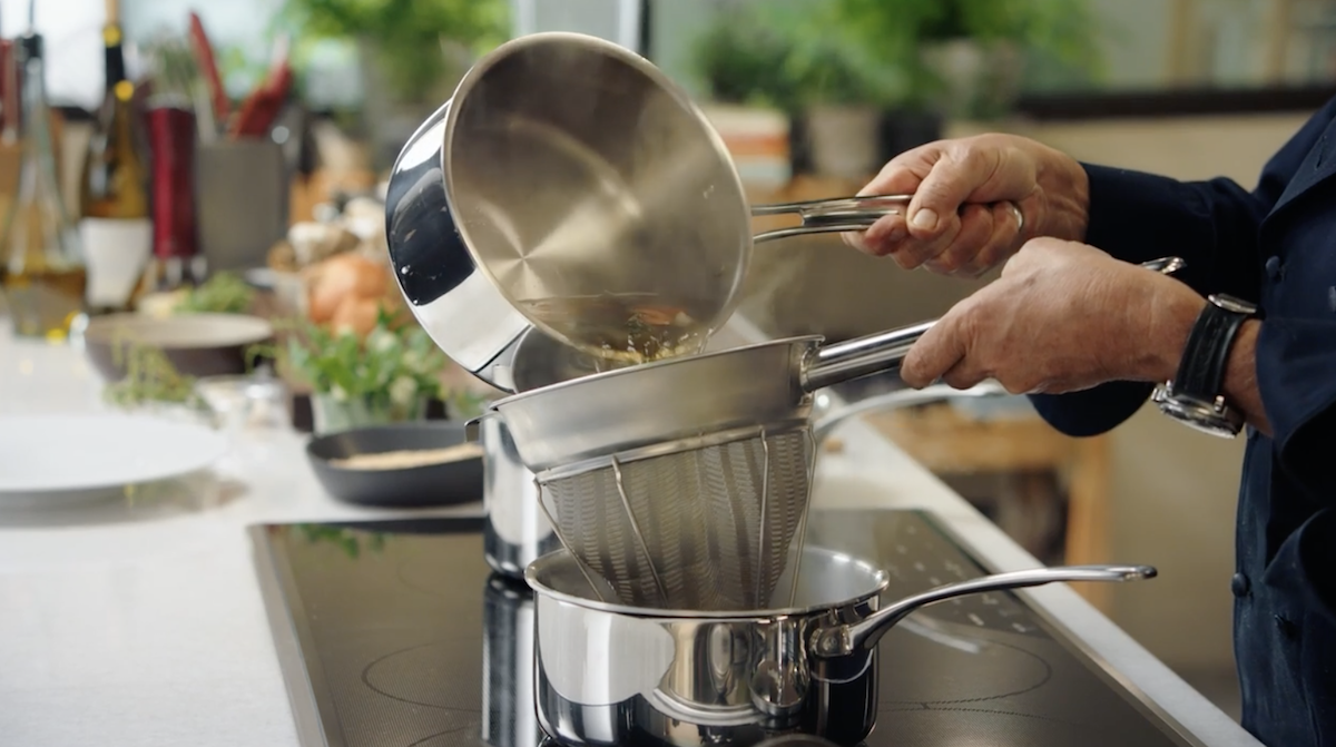 Wolfgang Puck pouring broth into strainer