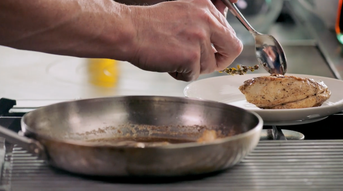 Gordon Ramsay serving chicken on plate from pan