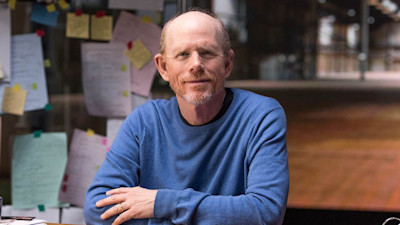Ron Howard sitting at desk