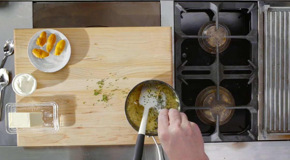 Gordon Ramsay adding herbs to scrambled eggs in pot