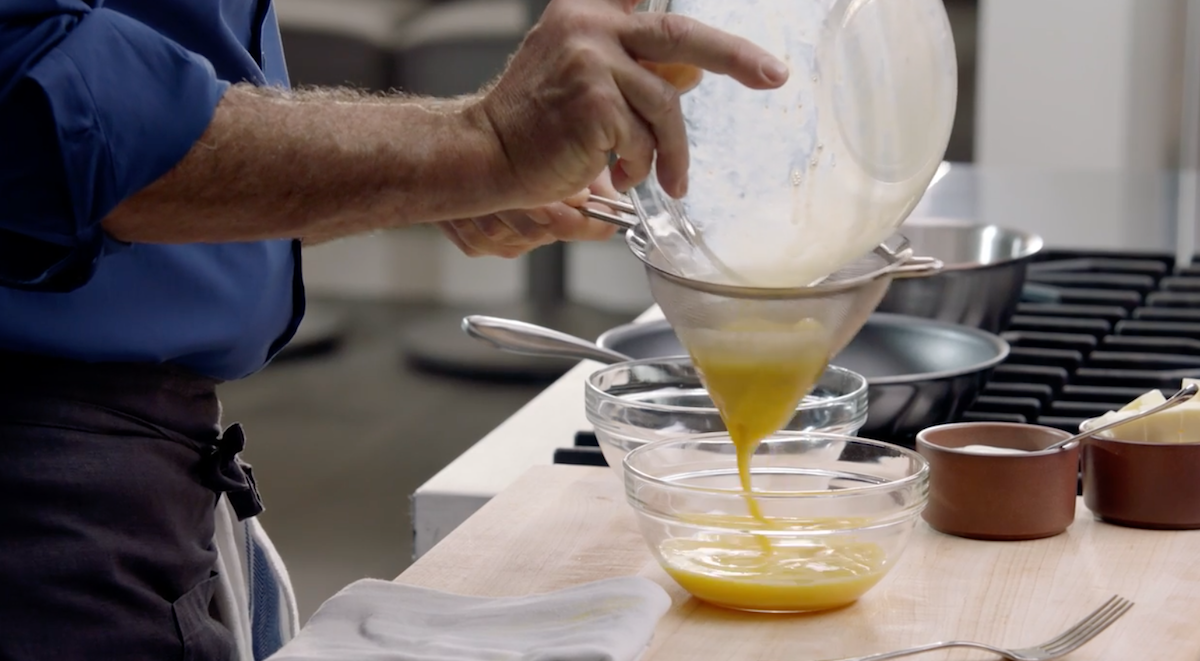 Thomas Keller straining eggs into bowl