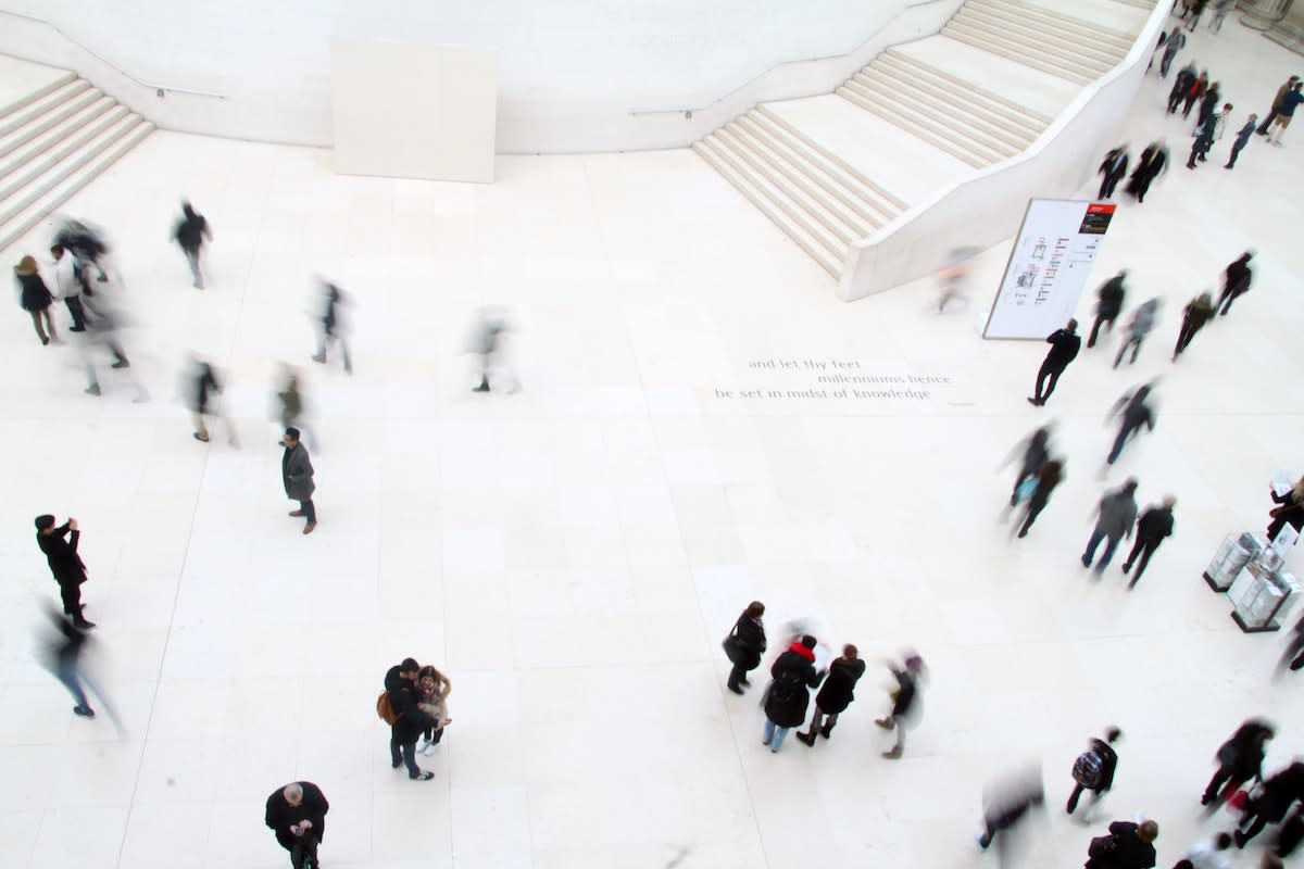 Crowd of blurry people in white museum