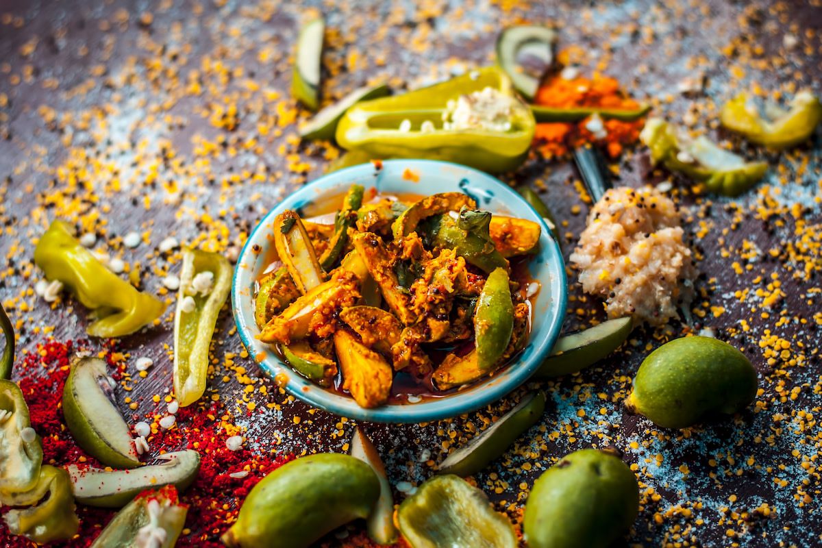 Achaar pickles in bowl with spices and peppers