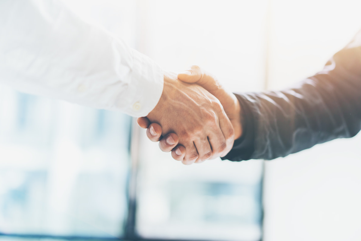 an image of two businesspeople shaking hands as an example of the invisible hand