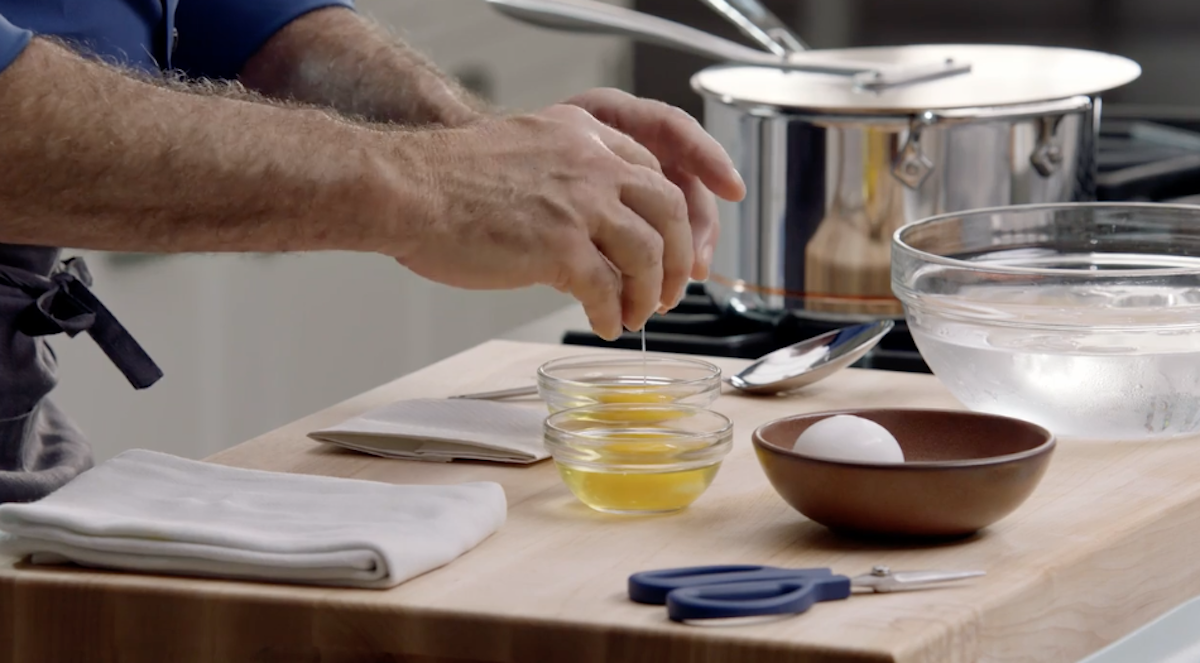 Chef Thomas Keller cracking eggs into small glass bowls